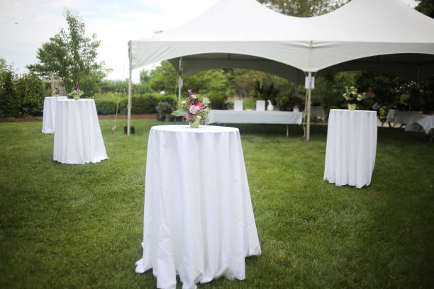 9F934404-1973-4376-9BD7-9AA678AAA245 White Tents and High top Tables for an Outdoor Garden Event with Pink and Purple Centerpieces